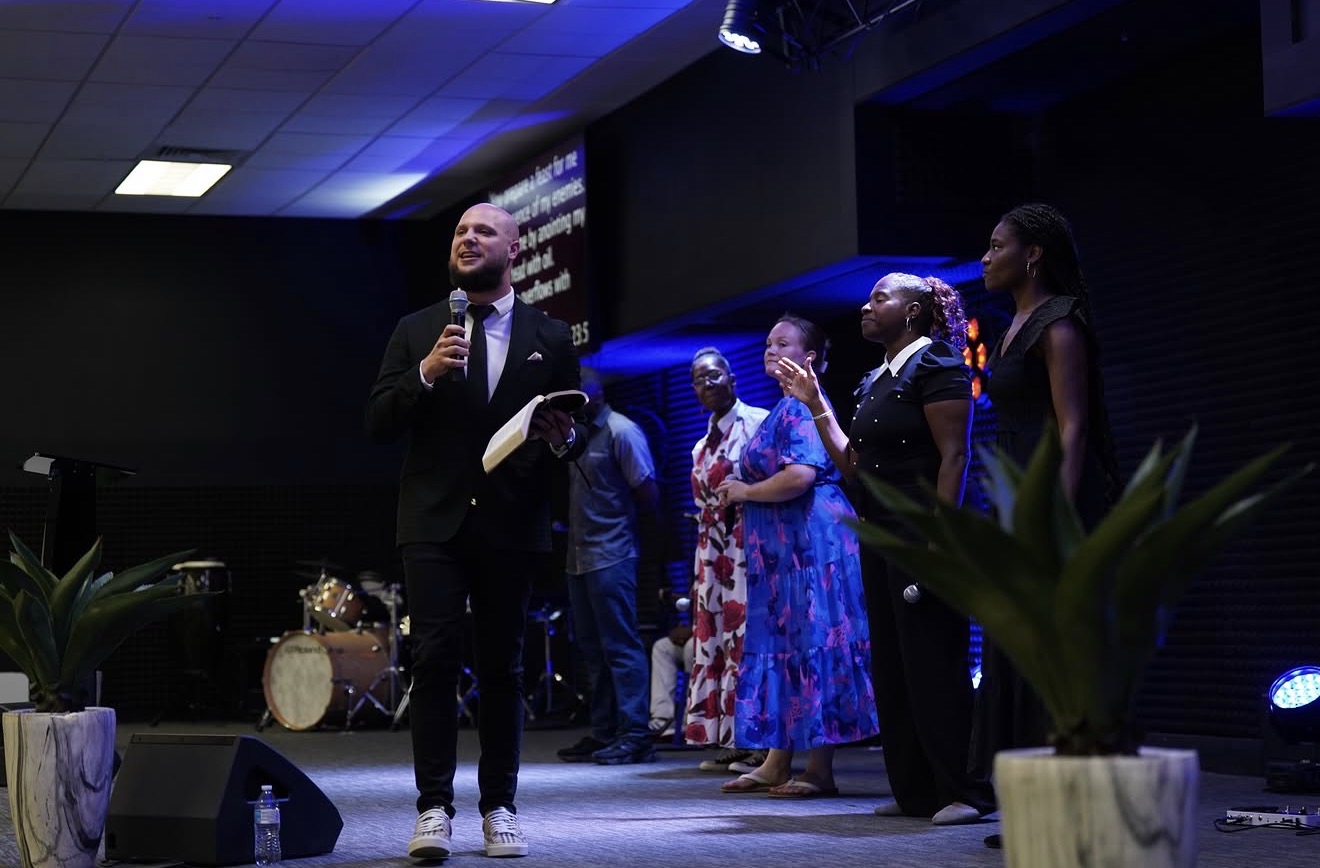 Travis Ventrella preaching on stage at River Church Baltimore